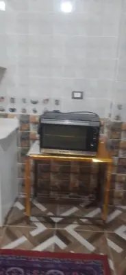 a microwave sitting on a table in a room at Sphinx Avenue street in Luxor