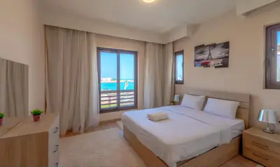 a bedroom with a bed and a large window at Luxury Stays in Ancient Sands El Gouna in Hurghada