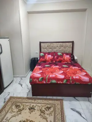 a bedroom with a red bed with flowers on it at Fully furnished studio with all services and amenities close to the beach in Hurghada