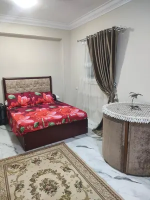 a bedroom with a bed and a table and a rug at Fully furnished studio with all services and amenities close to the beach in Hurghada