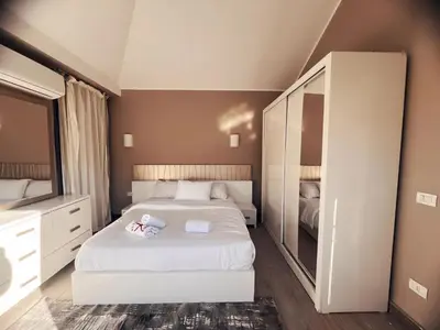 a bedroom with a white bed and a large mirror at Bali A 22 in Hurghada