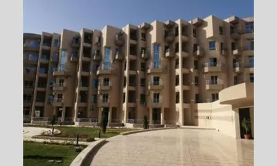 a large apartment building with a parking lot in front of it at princess resort ,arch angilos Hurghada in Hurghada