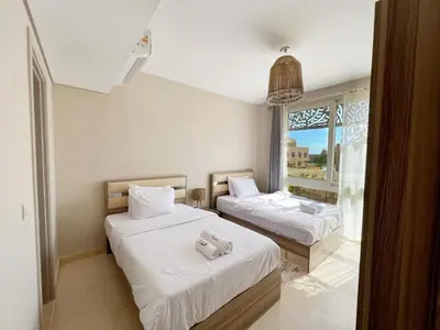 a bedroom with two beds with white sheets and a window at Luxury 5 Bedrooms Sea Front Villa in Hurghada