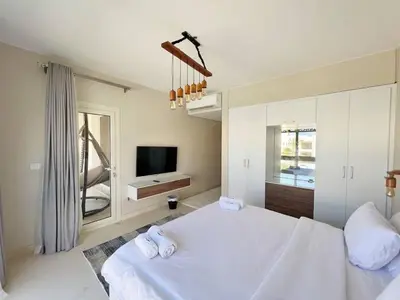 a bedroom with a white bed and a tv at Luxury 5 Bedrooms Sea Front Villa in Hurghada