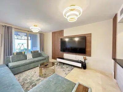 a living room with a couch and a flat screen tv at Luxury 5 Bedrooms Sea Front Villa in Hurghada
