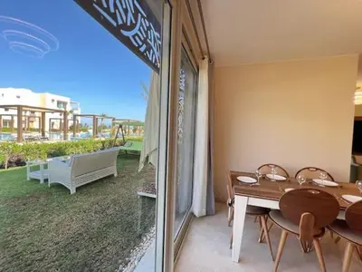 a dining room with a table and a view of a yard at Luxury 5 Bedrooms Sea Front Villa in Hurghada