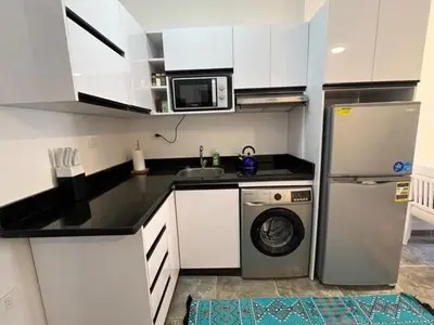 a kitchen with a washing machine and a microwave at Aqua Infinity Oasis walking distance to beach, 15 minutes from El Gouna, 15 minutes from central Hurghada in Hurghada