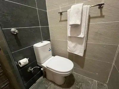 a bathroom with a white toilet and towels at Aqua Infinity Oasis walking distance to beach, 15 minutes from El Gouna, 15 minutes from central Hurghada in Hurghada