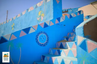 a blue wall with stairs in a room at Heissa Nubian Hostel in Aswân Reservoir Colony