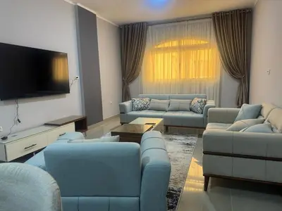a living room with couches and a flat screen tv at Inter Prime apartment 1 in Hurghada