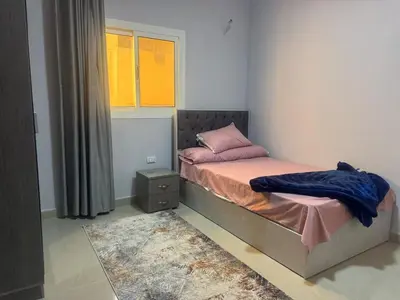a small bedroom with a bed and a window at Inter Prime apartment 1 in Hurghada