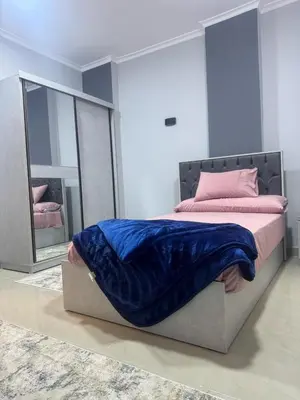 a bedroom with a bed with a blue blanket on it at Inter Prime apartment 1 in Hurghada