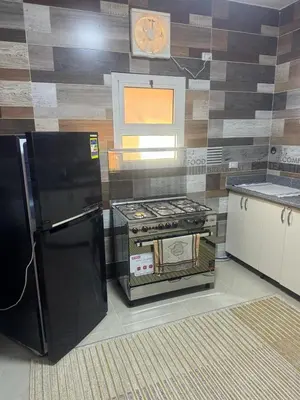 a kitchen with a black refrigerator and a clock on the wall at Inter Prime apartment 1 in Hurghada