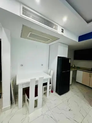 a kitchen with a white table and a black refrigerator at 005 flamingo building Cozy appartement-two beds-1st floor with elevator in Hurghada