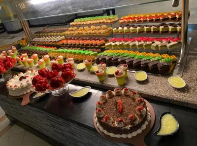 a buffet with a cake and many different desserts at Lilyland Beach Resort & Waterpark in Hurghada