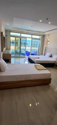 two beds in a large room with a large window at Lilyland Beach Resort & Waterpark in Hurghada