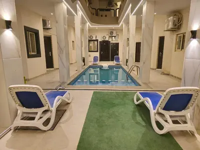 a swimming pool with two chairs and a pool table at Dive Hostel Hurghada Sea Light in Hurghada