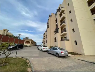 two cars parked in a parking lot next to a building at Modern apartment in Hurghada al dau heights 3314 in Hurghada