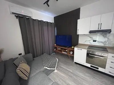 a living room with a gray couch and a tv at Imperial Resort Hurghada in Hurghada