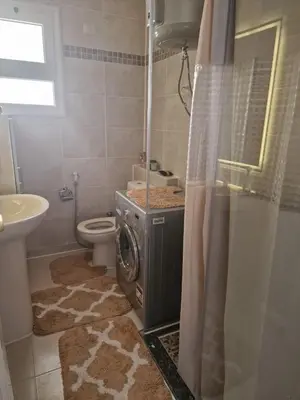 a bathroom with a washing machine in a shower at Apartment for rent 2 bed rooms in Hurghada