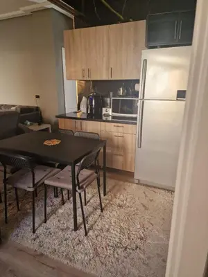 a kitchen with a black table and a white refrigerator at Apartment for rent 2 bed rooms in Hurghada