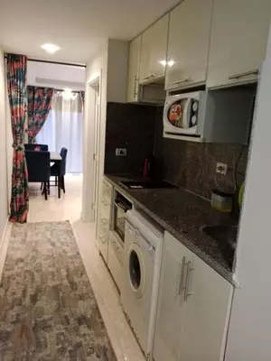 a kitchen with a washing machine and a microwave at Selena Bay Resort in Hurghada
