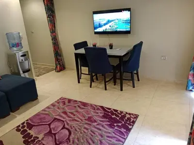 a dining room with a table and chairs and a tv at Selena Bay Resort in Hurghada