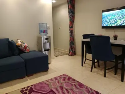 a living room with a blue couch and a table at Selena Bay Resort in Hurghada