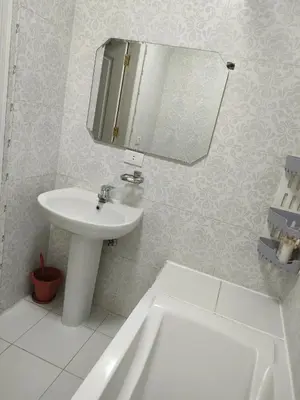 a white bathroom with a sink and a mirror at Apartment for rent in Hurghada