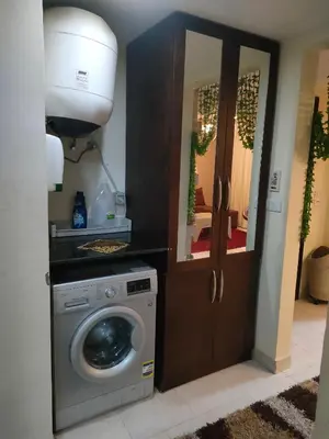 a laundry room with a washing machine and a mirror at Apartment for rent in Hurghada