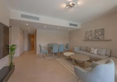 a living room with a couch and a table and chairs at Sea View 2BR Mangroovy Gouna I Swimming Pool and Red Sea Beach in Hurghada