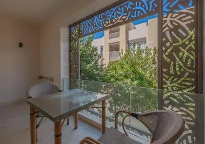 a balcony with a glass table and chairs and a window at Sea View 2BR Mangroovy Gouna I Swimming Pool and Red Sea Beach in Hurghada
