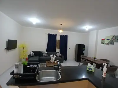 a kitchen and living room with a couch and a sink at Cozy Apartment in Hurghada