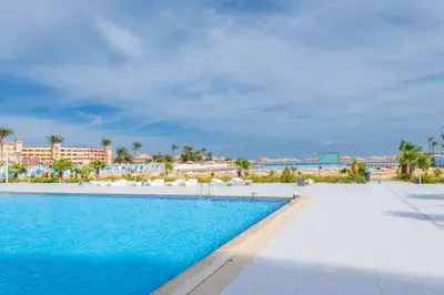 a swimming pool at the resort with the beach in the background at Scandic Resort Hurghada مبني سكندك رزوت الغردقة in Hurghada