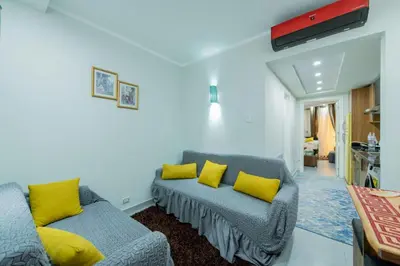 a living room with a couch and yellow pillows at Scandic Resort Hurghada مبني سكندك رزوت الغردقة in Hurghada