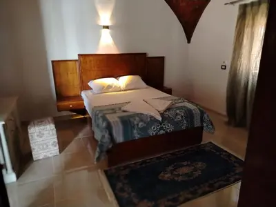 a bedroom with a bed with a wooden headboard at Mena Palace Nile View in Luxor