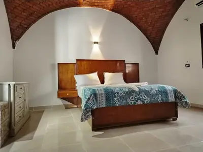 a bedroom with a bed and a dresser at Mena Palace Nile View in Luxor