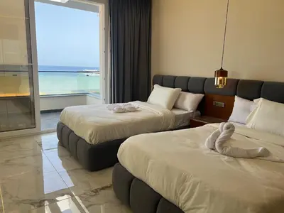 a hotel room with two beds and a couch at Villa KUBA luxury in Hurghada