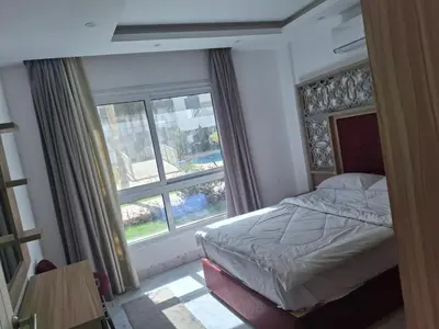 a bedroom with a bed and a large window at Fanadir Bay apartment in Hurghada