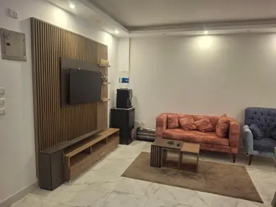 a living room with a couch and a flat screen tv at Fanadir Bay apartment in Hurghada