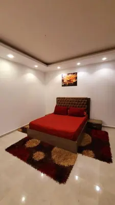 a bedroom with a red bed in a room at touristic centre hurghada in Hurghada