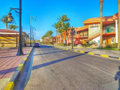 an empty city street with palm trees and buildings at touristic centre hurghada in Hurghada