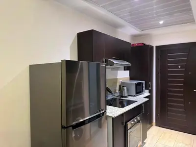 a kitchen with a stainless steel refrigerator and a microwave at Golden Aldau Heights studio Hurghada 1019 in Hurghada