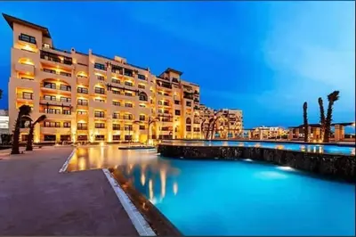 a large building next to a body of water at Studio in Dow Heights Compound in Hurghada