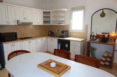 a kitchen with a white table and a white counter top at Spacious 1bd on the Beach - White Villas, El Gouna in Hurghada