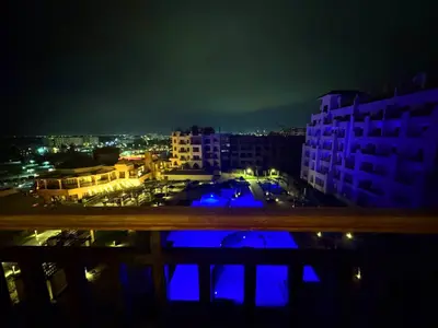 a view of a city at night with blue lights at the flower of the sea in Hurghada