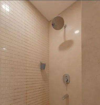 a shower in a bathroom with white tile at Mangroovy- 1br GF Waterfront Glitzy direct pool in Hurghada