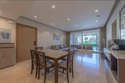 a kitchen and dining room with a table and chairs at Mangroovy- 1br GF Waterfront Glitzy direct pool in Hurghada