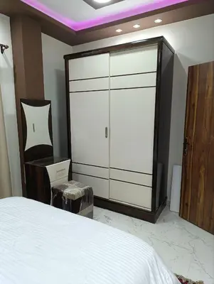 a bedroom with a white bed and a large closet at براديس الاحياء in Hurghada