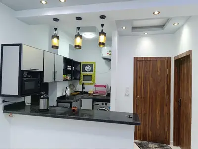 a kitchen with a counter and a wooden door at براديس الاحياء in Hurghada